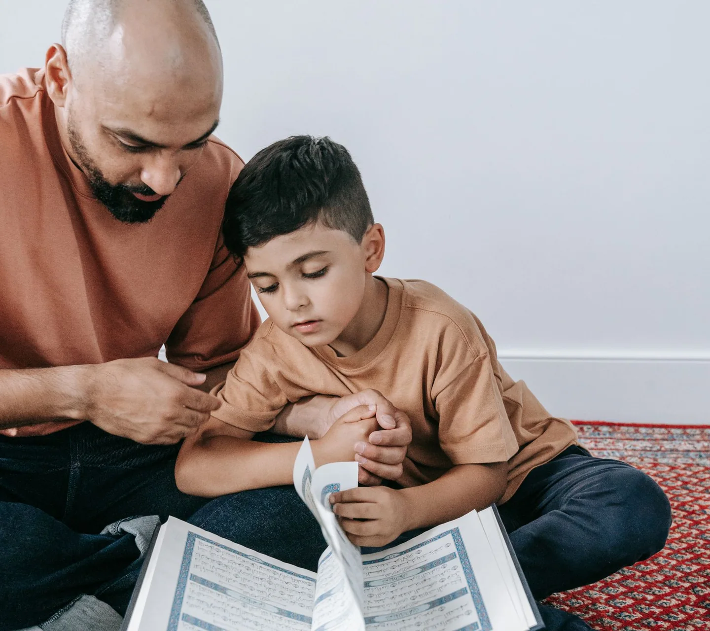 A father reading the Qur'an with his young son